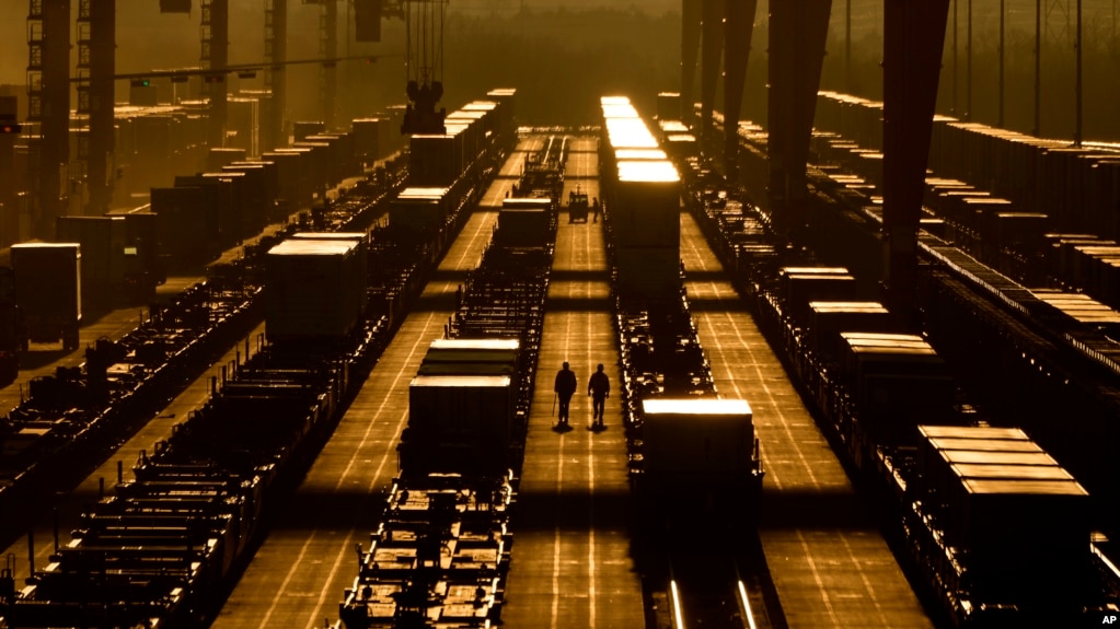 堪萨斯州埃杰顿，工人们在BNSF货运铁路联运码头的集装箱中间行走